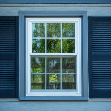 replacement window with dark blue shutters