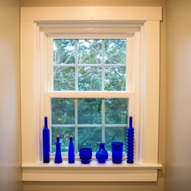 Lentz - blue glass bottles along a window sill