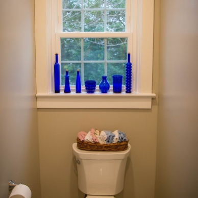 Lentz - blue glass bottles on a window sill in remodeled bathroom