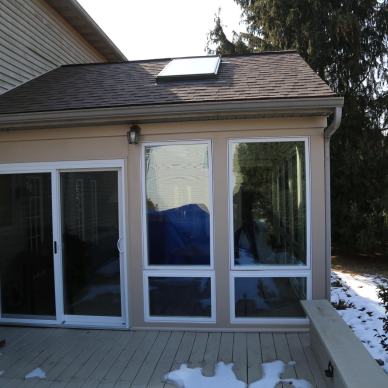 Thomas - exterior view of sliding glass patio doors and windows on three-season home addition from the attached deck