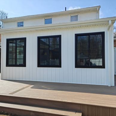 Kremser - exterior of new addition with white siding and black frame windows and new deck