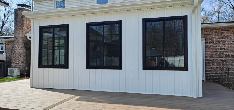 Kremser - exterior of new addition with white siding and black frame windows and new deck