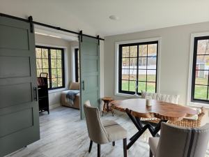 Kremser - interior of new addition with dining area and view of home office area separate by sliding barn-style doors
