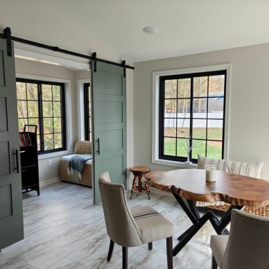 Kremser - interior of new addition with dining area and view of home office area separate by sliding barn-style doors