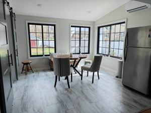 Kremser - interior of new addition with large windows with grids, interior sliding doors, dining area, and refrigerator