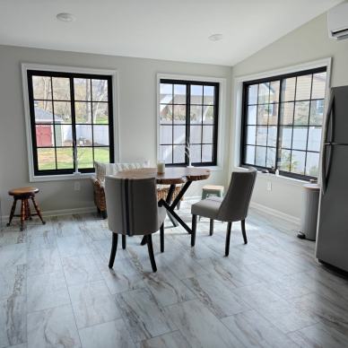 Kremser - interior of new addition with large windows with grids, interior sliding doors, dining area, and refrigerator