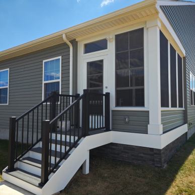 McKay enclosure - finished porch conversion into a 3-season enclosure with front steps and railings and stone siding accent